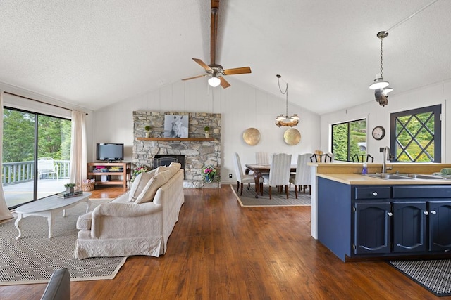 2793 Hidden Valley Rd, Hiawassee, GA 30546 - living area with dark wood-style flooring, ceiling fan, vaulted ceiling, a stone fireplace, and a textured ceiling