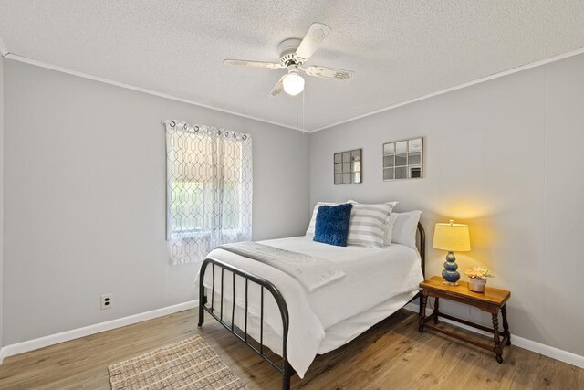 2793 Hidden Valley Rd, Hiawassee, GA 30546 - bedroom with a textured ceiling, ornamental molding, wood finished floors, and ceiling fan