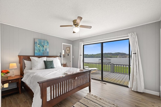 2793 Hidden Valley Rd, Hiawassee, GA 30546 - bedroom featuring access to exterior, a water view, wood finished floors, a ceiling fan, and a textured ceiling
