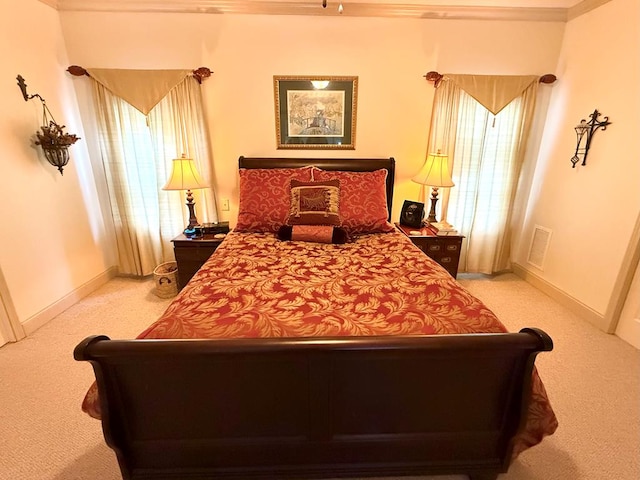 carpeted bedroom with crown molding and multiple windows