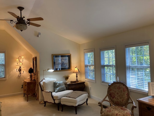 living area with ceiling fan, light colored carpet, and vaulted ceiling