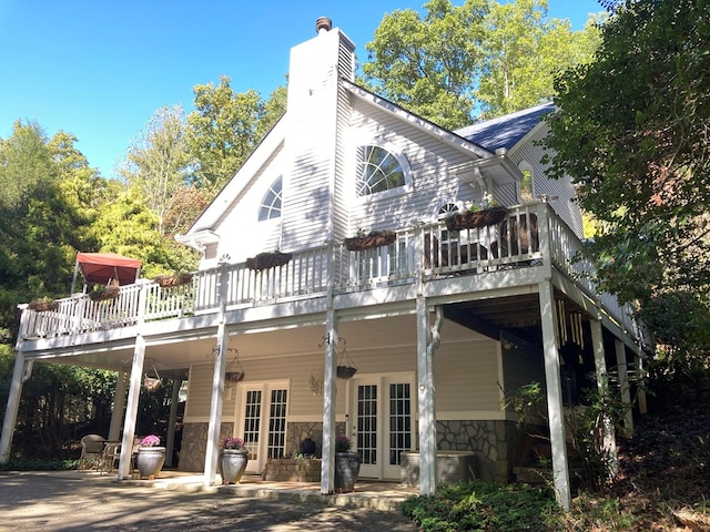 rear view of property featuring french doors and a deck