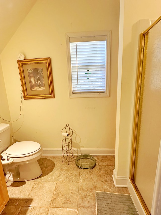 bathroom with toilet, lofted ceiling, and walk in shower