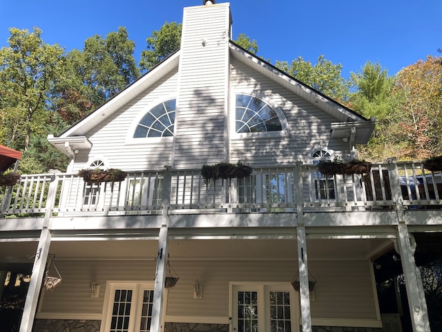 back of property featuring a deck and a balcony