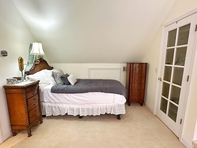 bedroom with light colored carpet and vaulted ceiling