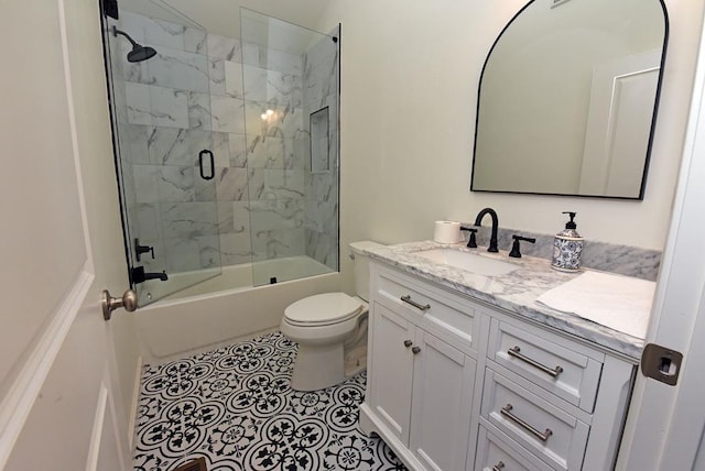 bathroom featuring toilet, tile patterned floors, combined bath / shower with glass door, and vanity