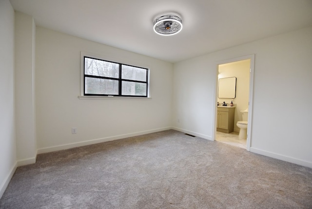 unfurnished bedroom featuring light colored carpet, sink, and connected bathroom