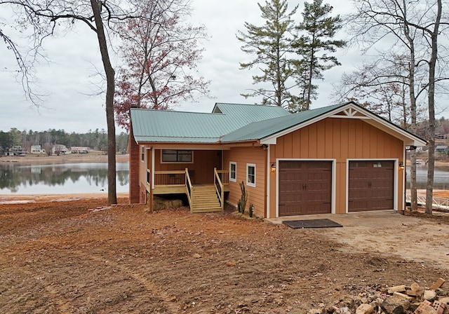 view of front of house with a water view, a porch, and a garage