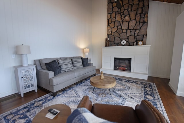 living area featuring a fireplace, wood finished floors, and baseboards