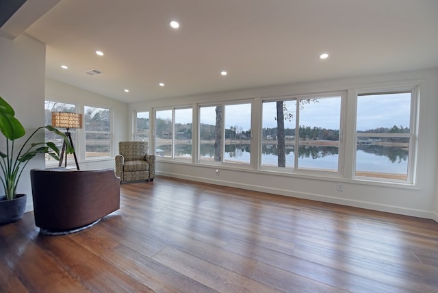 living area featuring recessed lighting, visible vents, a water view, and wood finished floors