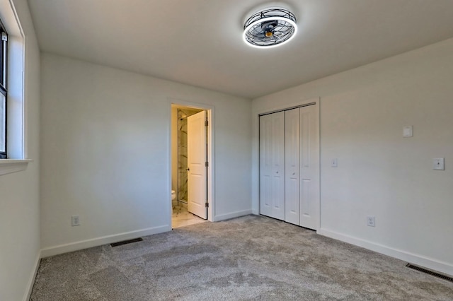 unfurnished bedroom with baseboards, a closet, visible vents, and carpet flooring