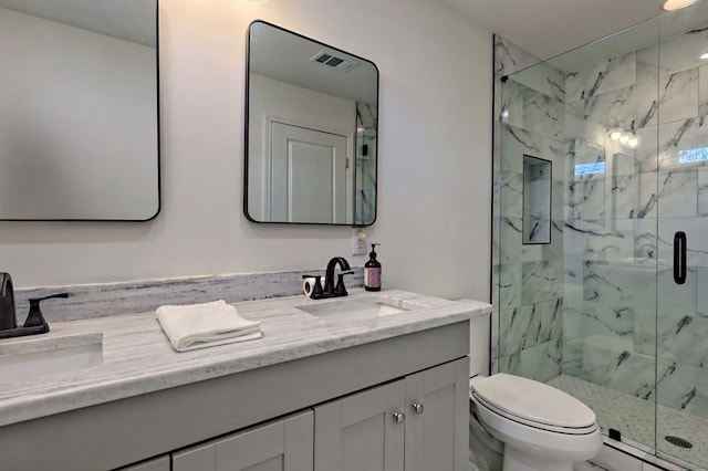 bathroom with double vanity, a sink, and a marble finish shower