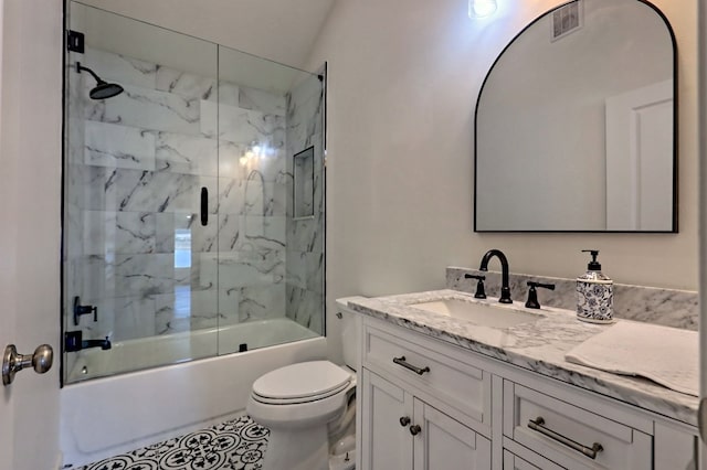 full bath featuring toilet, visible vents, bath / shower combo with glass door, and vanity