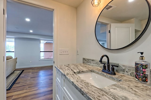 bathroom featuring recessed lighting, visible vents, vanity, wood finished floors, and baseboards