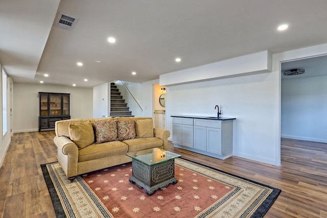 living area featuring stairs, visible vents, wood finished floors, and recessed lighting