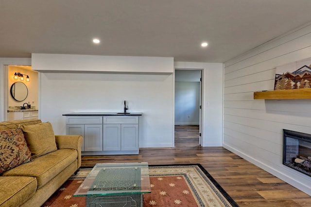 living room featuring baseboards, dark wood-style flooring, a fireplace, and recessed lighting