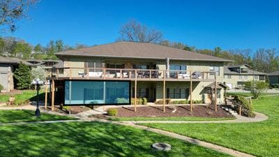 rear view of property featuring a lawn