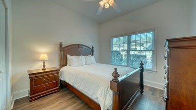 bedroom featuring ceiling fan, hardwood / wood-style floors, and lofted ceiling