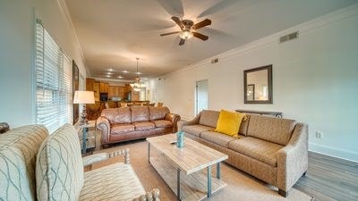 living room featuring ceiling fan and crown molding