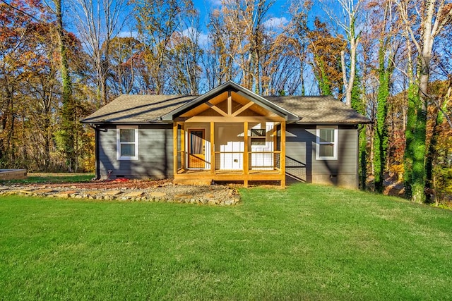 view of front of house with a front yard and a sunroom