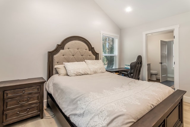 bedroom with connected bathroom, light hardwood / wood-style flooring, and lofted ceiling