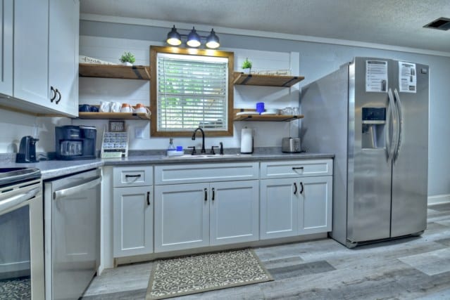 151 Padget Ln, Ellijay, GA 30540 - kitchen with stainless steel appliances, open shelves, light wood-style flooring, a sink, and a textured ceiling