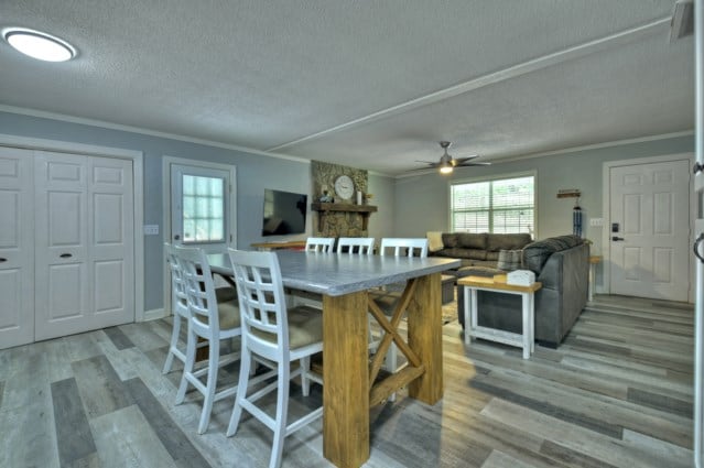 151 Padget Ln, Ellijay, GA 30540 - dining room with light wood finished floors, ornamental molding, a textured ceiling, and ceiling fan