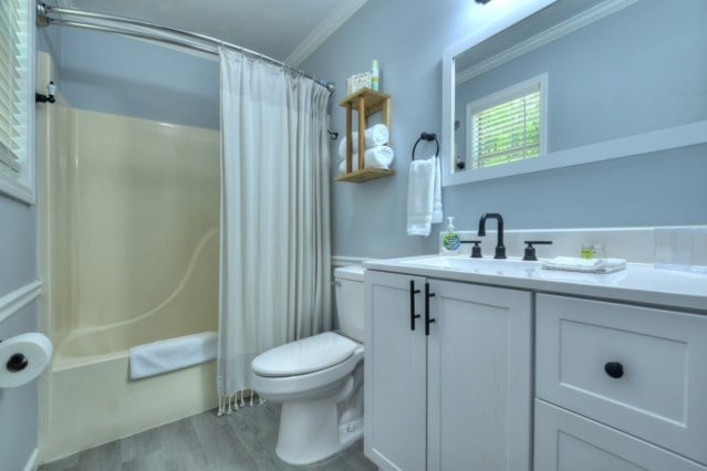 151 Padget Ln, Ellijay, GA 30540 - full bath featuring toilet, crown molding, wood finished floors, vanity, and shower / bathtub combination with curtain