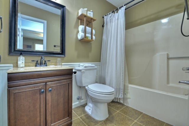 151 Padget Ln, Ellijay, GA 30540 - full bathroom with toilet, tile patterned floors, vanity, shower / bath combo with shower curtain, and a wainscoted wall