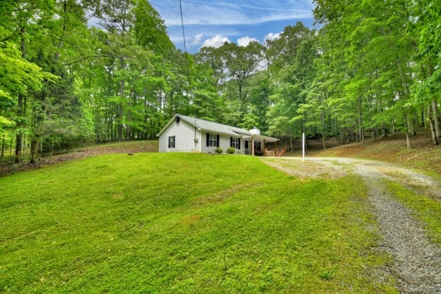 151 Padget Ln, Ellijay, GA 30540 - ranch-style home with dirt driveway, a front lawn, a chimney, and a view of trees