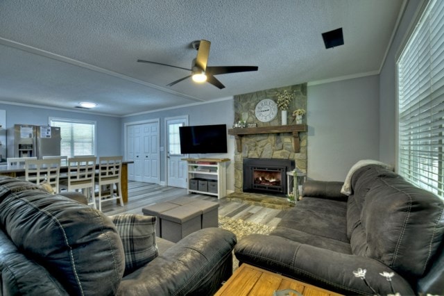 151 Padget Ln, Ellijay, GA 30540 - living area with wood finished floors, ornamental molding, a textured ceiling, ceiling fan, and a stone fireplace