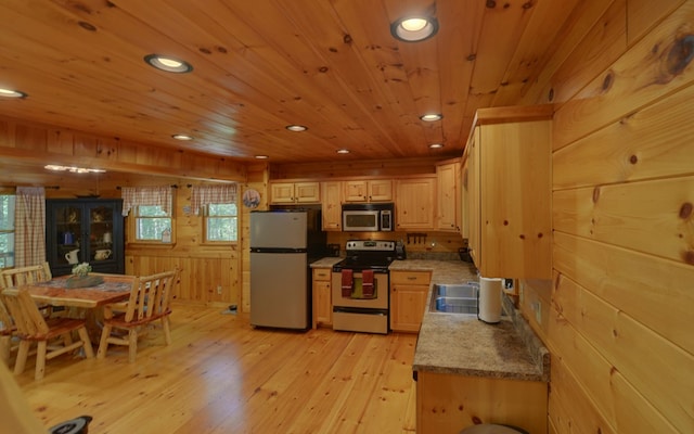 kitchen featuring light brown cabinets, wooden ceiling, wood walls, appliances with stainless steel finishes, and light wood-type flooring