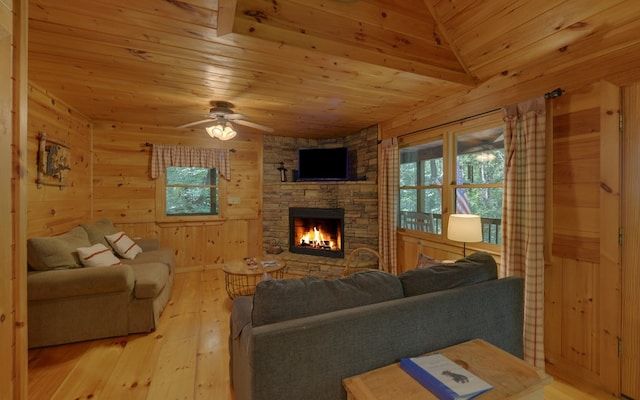 living room with ceiling fan, light hardwood / wood-style flooring, wooden walls, a fireplace, and wood ceiling