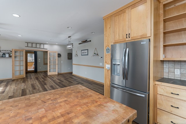 kitchen featuring light brown cabinetry, backsplash, stainless steel fridge with ice dispenser, pendant lighting, and dark hardwood / wood-style flooring