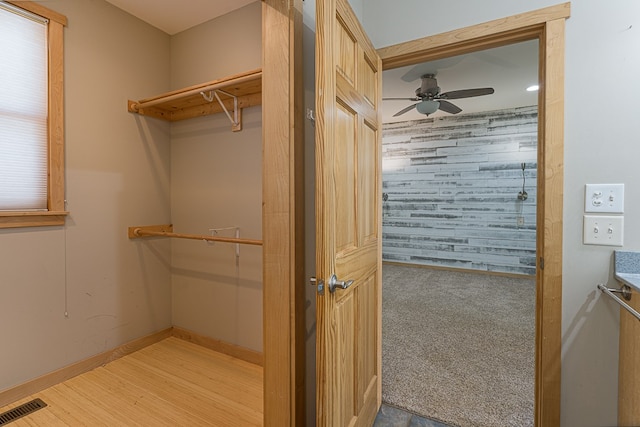 walk in closet with light hardwood / wood-style floors and ceiling fan