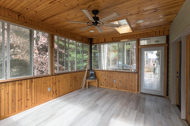 unfurnished sunroom with a healthy amount of sunlight, wood ceiling, and a skylight