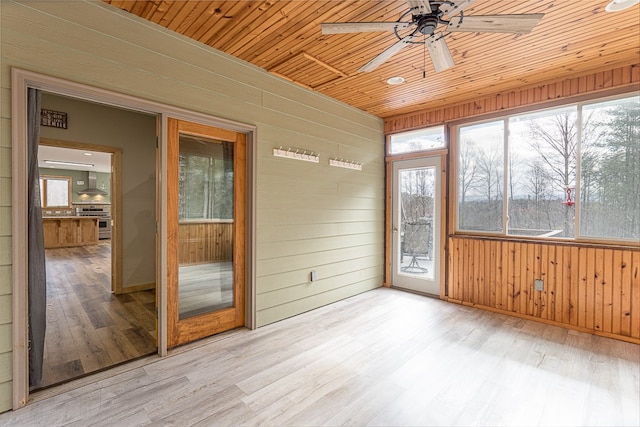 unfurnished sunroom featuring wood ceiling and ceiling fan