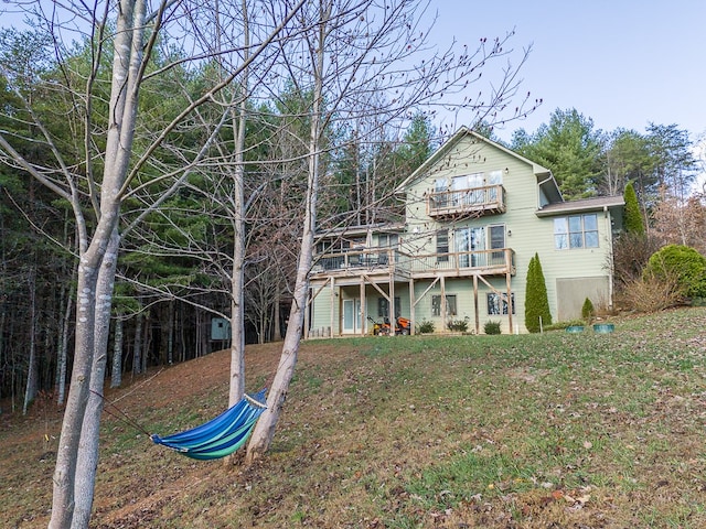 exterior space with a wooden deck, a yard, and a balcony