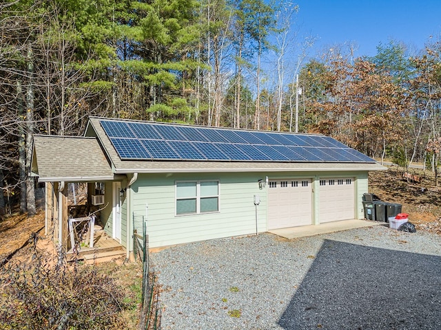 exterior space featuring a garage and solar panels