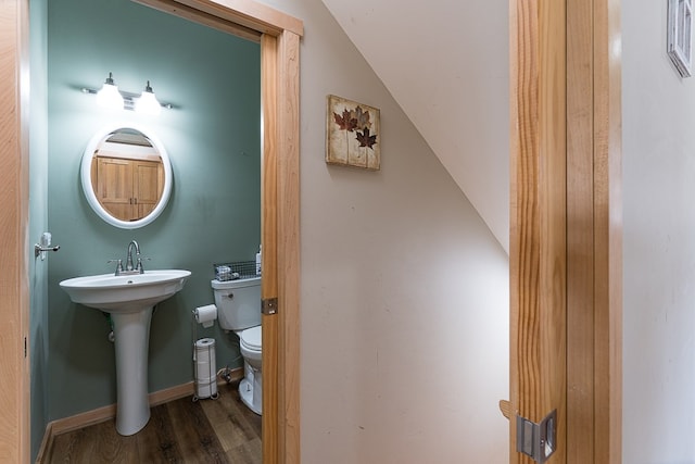 bathroom with toilet, lofted ceiling, and hardwood / wood-style flooring