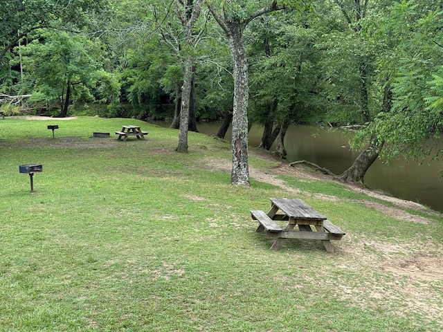 view of home's community with a water view and a yard