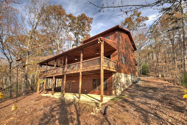 back of property with ceiling fan, a balcony, a patio, and a wooden deck