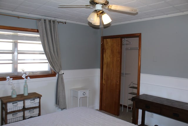 bedroom with ornamental molding, ceiling fan, and a closet