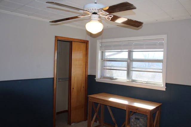 interior space with crown molding and ceiling fan