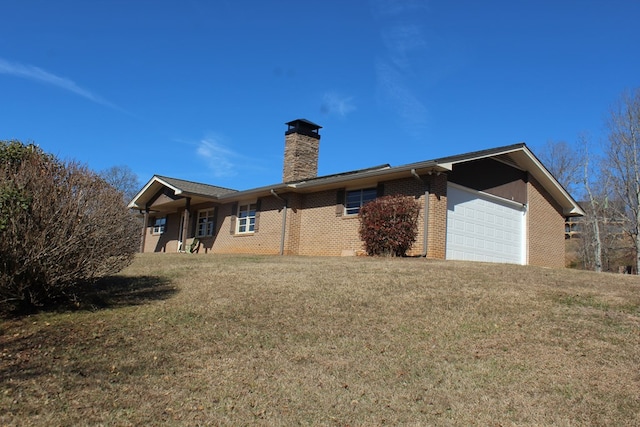 back of house with a garage and a yard