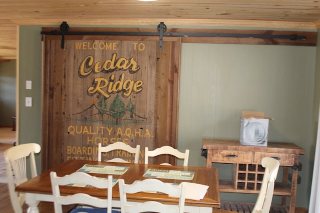 dining room with wooden walls and a barn door