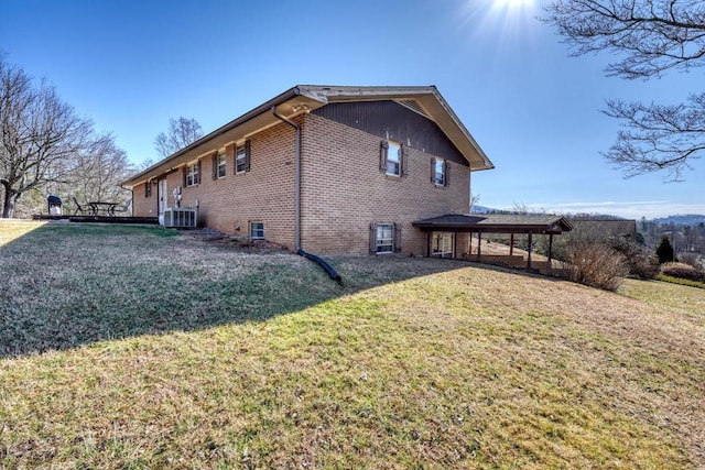 view of side of home with central AC and a yard