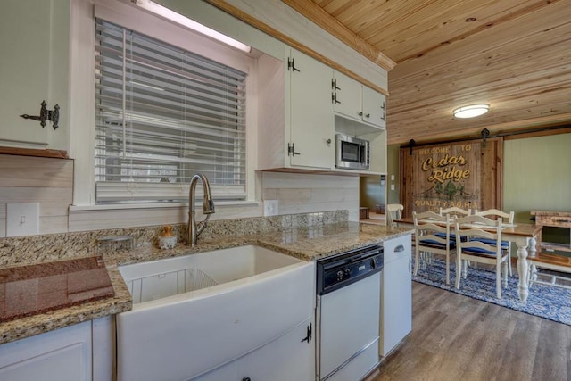 kitchen featuring light wood-type flooring, wooden ceiling, white dishwasher, a barn door, and white cabinets