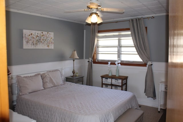 carpeted bedroom featuring crown molding and ceiling fan