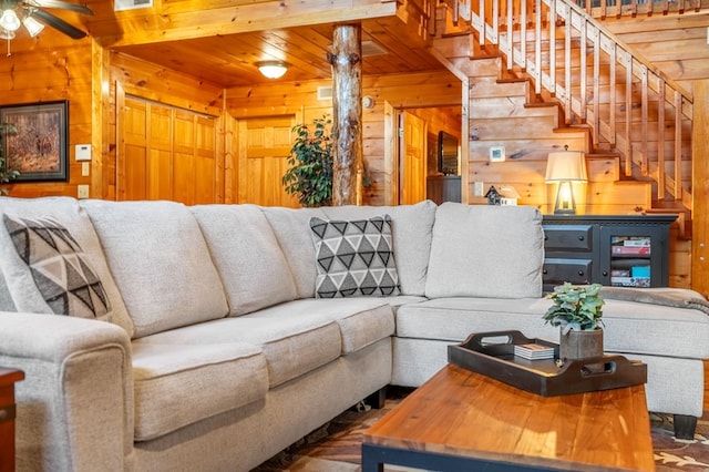 living room featuring wooden ceiling, ceiling fan, and wood walls